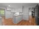 Bright kitchen featuring white cabinets, granite counters, subway tile backsplash and view into living room at 129 Castle Dr, Smithfield, NC 27577