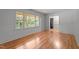 Bright living room with hardwood floors and large windows offers ample natural light and views of the outdoor scenery at 129 Castle Dr, Smithfield, NC 27577