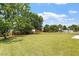 Wide-open backyard with a wooden fence, mature trees, and lush grass at 1325 Sweetclover Dr, Wake Forest, NC 27587