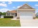 View of the attractive home featuring a two-car garage, manicured front lawn and mature landscaping at 1325 Sweetclover Dr, Wake Forest, NC 27587