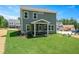 Backyard view of a house featuring a screened-in porch, lush lawn, and exterior with blue siding at 134 Beacon Dr, Pittsboro, NC 27312
