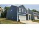 Side view of a two-story home with blue siding and a white garage door at 134 N Keatts Winner Ct, Wilson's Mills, NC 27520