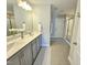 Bright bathroom with double vanity, large mirror, and tiled floors at 1412 Queen Trigger Dr, Fuquay Varina, NC 27526