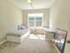 Sunlit bedroom featuring a cozy twin bed, desk, and a view of the backyard at 1412 Queen Trigger Dr, Fuquay Varina, NC 27526
