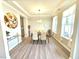 Elegant dining room with tray ceilings, featuring a modern light fixture, and a large window with sheer curtains at 1412 Queen Trigger Dr, Fuquay Varina, NC 27526