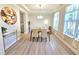 Elegant dining room with tray ceilings, featuring a modern light fixture, and a large window with sheer curtains at 1412 Queen Trigger Dr, Fuquay Varina, NC 27526