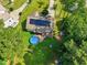 Aerial view showcases backyard with a round pool, mature trees, and solar panels at 153 Hickory Nut Dr, Smithfield, NC 27577