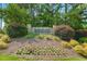 Community entrance featuring stone signage, landscaping, and floral accents at 153 Hickory Nut Dr, Smithfield, NC 27577