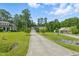 Charming home with a long drive, lush lawn, and mature trees under a blue sky at 153 Hickory Nut Dr, Smithfield, NC 27577