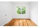 Sunlit bedroom with hardwood floors and a view of lush greenery outside the window at 1621 Ella Wiggins Way, Raleigh, NC 27603