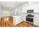 Modern kitchen with stainless steel appliances, white cabinetry, island and open floor plan at 1621 Ella Wiggins Way, Raleigh, NC 27603