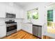 Beautiful kitchen features stainless steel appliances, quartz countertops, and access to the deck at 1621 Ella Wiggins Way, Raleigh, NC 27603