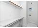 Clean laundry room featuring quartz counter, storage shelf, and tile floor at 1621 Ella Wiggins Way, Raleigh, NC 27603