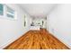 Bright living room featuring hardwood floors, white walls, and an open layout leading to the kitchen at 1621 Ella Wiggins Way, Raleigh, NC 27603