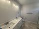 Bathroom features a double sink vanity, a modern lighting fixture, and tiled flooring at 165 Tee Dr, Selma, NC 27576