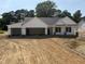 New construction home featuring a three car garage, white siding and stone accents at 165 Tee Dr, Selma, NC 27576
