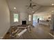 Spacious living room showcasing light wood flooring, a cozy fireplace, ceiling fan, and an abundance of natural light at 165 Tee Dr, Selma, NC 27576