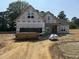 New construction home exterior with stacked lumber on the lot, awaiting final touches and landscaping at 183 Tee Dr, Selma, NC 27576