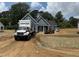 New construction home with blue siding, landscaping, and a Carter Lumber truck in the driveway at 183 Tee Dr, Selma, NC 27576