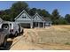 Charming home featuring hardiplank siding, an attached garage, and a covered front porch in a partially cleared lot at 183 Tee Dr, Selma, NC 27576