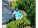 Aerial view of a home and pool with umbrellas, landscaping, and inviting backyard at 205 Silent Cove Ln, Holly Springs, NC 27540