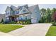 Charming two-story home with a well-manicured lawn, colorful flowers, and a welcoming driveway at 205 Silent Cove Ln, Holly Springs, NC 27540