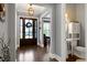 Charming foyer with hardwood floors, a statement front door, and a glimpse of a nearby powder room at 205 Silent Cove Ln, Holly Springs, NC 27540