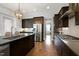 Well-equipped kitchen featuring stainless steel appliances, dark cabinetry, and a central island at 205 Silent Cove Ln, Holly Springs, NC 27540
