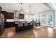 Spacious kitchen boasts dark cabinets, stainless appliances, and island with barstool seating at 205 Silent Cove Ln, Holly Springs, NC 27540