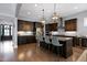 Modern kitchen includes dark cabinetry, stainless appliances, and an island with seating at 205 Silent Cove Ln, Holly Springs, NC 27540