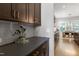 Contemporary kitchen with dark cabinets, stone countertops, and stainless steel accents at 205 Silent Cove Ln, Holly Springs, NC 27540