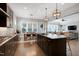 Open-concept kitchen with a central island, dark cabinets, and adjacent dining area at 205 Silent Cove Ln, Holly Springs, NC 27540