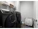 Modern laundry room features a washer and dryer set with storage and counter space for convenience at 205 Silent Cove Ln, Holly Springs, NC 27540