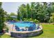 Beautiful backyard pool with patio, waterfall feature and Adirondack chairs surrounding a fire pit at 205 Silent Cove Ln, Holly Springs, NC 27540