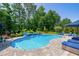 A luxurious backyard pool featuring a waterfall, landscaping, and comfortable lounge seating for relaxation at 205 Silent Cove Ln, Holly Springs, NC 27540