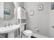 Charming powder room featuring a pedestal sink, decorative mirror, and neutral decor at 205 Silent Cove Ln, Holly Springs, NC 27540