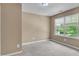 A carpeted bedroom with a window and neutral walls is naturally lit at 211 Westgrove Ct, Durham, NC 27703