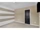 A carpeted bedroom features tan and white horizontal stripes on the accent wall at 211 Westgrove Ct, Durham, NC 27703