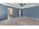 Bright main bedroom featuring carpet floors, neutral walls, a ceiling fan, and two windows at 211 Westgrove Ct, Durham, NC 27703
