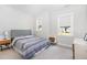 Neutral bedroom with a blue striped bedspread, side tables, and bright windows at 2128 Jollay St, Durham, NC 27703