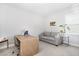 Bright office with desk, gray couch, and ample natural light at 2128 Jollay St, Durham, NC 27703