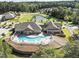 Aerial view of community pool with lounge chairs, umbrellas, and clubhouse at 2128 Jollay St, Durham, NC 27703