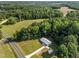 An aerial view showcasing the house, shed, and driveway nestled within lush greenery, illustrating a serene setting at 2210 Pilot-Riley Rd, Zebulon, NC 27597