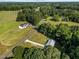 An aerial view capturing the house, shed, driveway, and surrounding verdant landscape, showcasing the property's layout at 2210 Pilot-Riley Rd, Zebulon, NC 27597