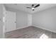 Neutral bedroom featuring hardwood floors, ceiling fan, and two entry doors at 2210 Pilot-Riley Rd, Zebulon, NC 27597