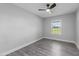 Bedroom featuring hardwood floors, ceiling fan, and bright window with neighborhood views at 2210 Pilot-Riley Rd, Zebulon, NC 27597