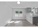 Bright dining area with gray wood-look flooring and view into the renovated kitchen at 2210 Pilot-Riley Rd, Zebulon, NC 27597