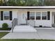 Charming home with a white brick exterior, dark shutters, and manicured landscaping at 2210 Pilot-Riley Rd, Zebulon, NC 27597