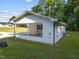 Back view showing a well-maintained white brick home with a covered carport and a neatly trimmed lawn at 2210 Pilot-Riley Rd, Zebulon, NC 27597