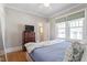 Sunny bedroom featuring wood floors, bright windows, and serene blue decor at 2225 Creston Rd, Raleigh, NC 27608